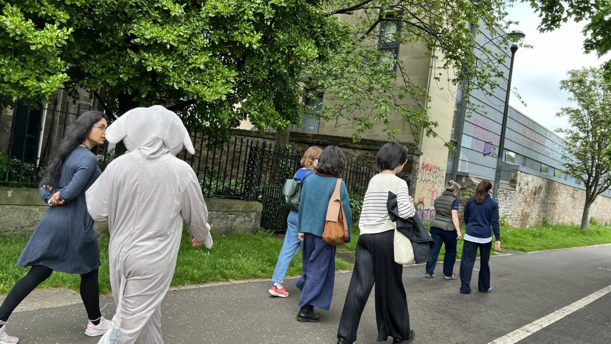 Students and person in elephant costume walking around Kings Buildings