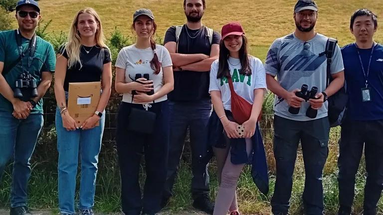 Group photo of students and Shona, wellbeing adviser, standing in a line outside on a pathway near a field