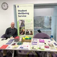 Man sitting behind table with promotional literature