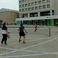 Four people playing pickle ball on a university campus