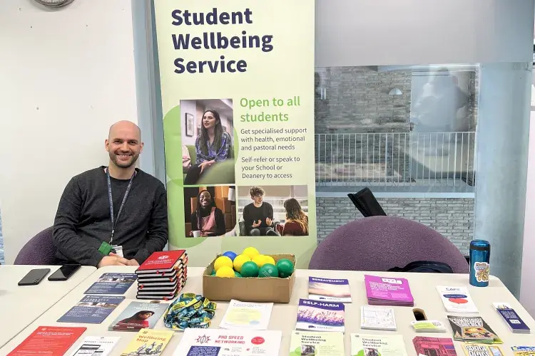 Man sitting behind table with promotional literature