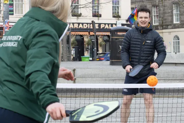 Woman and man playing paddleball