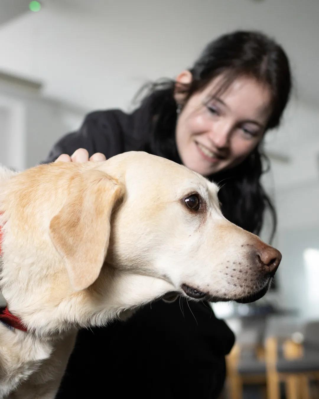 Female university student petting golden retriever