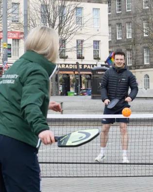 Woman and man playing paddleball