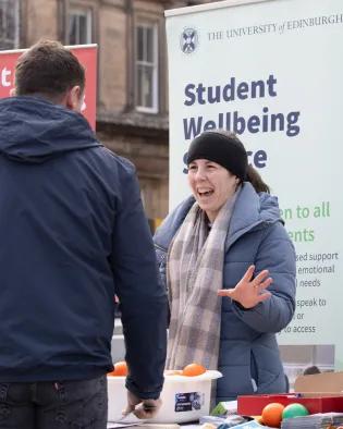 Woman standing in front of banner talking to a man